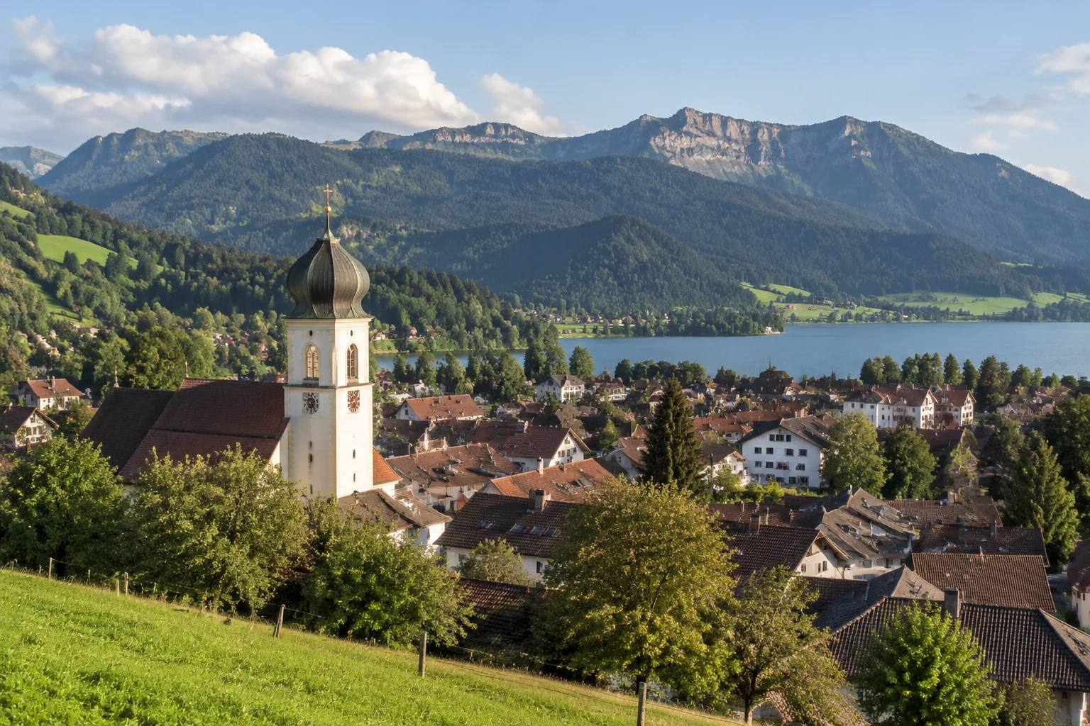 Immenstadt im Allgäu mit Altstadtdächern, dahinter der Große Alpsee und die Berge