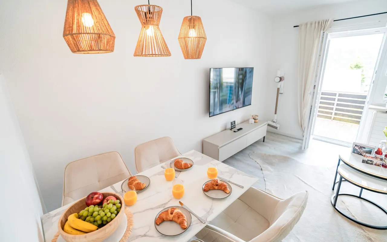 Heller Wohn- und Essbereich einer modernen Ferienwohnung in Immenstadt im Allgäu mit gedecktem Frühstückstisch