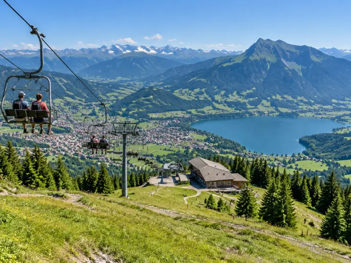 Sesselbahn am Mittag über Immenstadt, unten der Große Alpsee und die Stadt, dahinter der Grünten und die Allgäuer Alpen