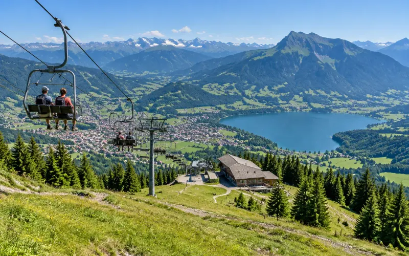 Sesselbahn am Mittag über Immenstadt, unten der Große Alpsee und die Stadt, dahinter der Grünten und die Allgäuer Alpen
