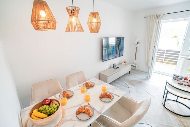 Heller Wohn- und Essbereich einer modernen Ferienwohnung in Immenstadt im Allgäu mit gedecktem Frühstückstisch